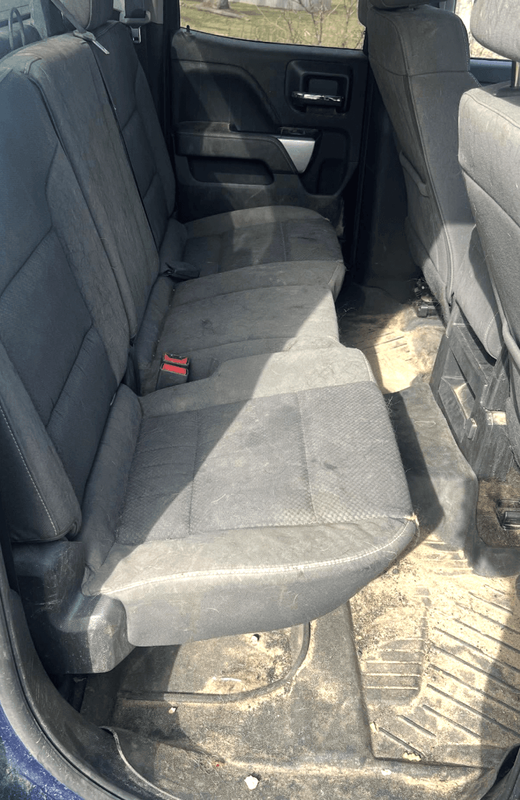 Chevy Silverado rear seat before detailing with dirt and stains on cloth seats